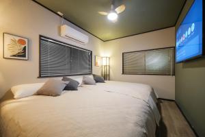 a bedroom with a large bed and a tv at SNUGGLE2222 Odawara Nakacho in Odawara