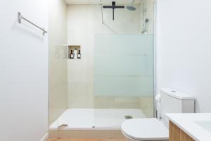 a white bathroom with a shower and a toilet at Almenara in Almenara