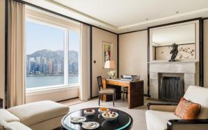 a living room with a fireplace and a large window at The Peninsula Hong Kong in Hong Kong