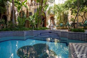 a swimming pool with blue tile in a yard at Ryad Salama in Fez