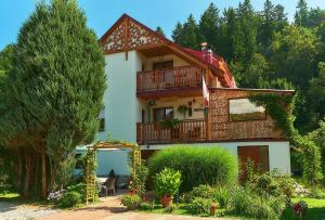 a house with a balcony on top of it at Willa Basinek in Muszyna