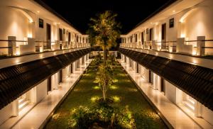 an empty building with a palm tree in the middle at Mahkota Hotel in Genteng-kulon