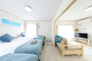 a bedroom with two beds and a tv in it at Shonan Beach&Sun in Chigasaki