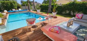 a swimming pool with a couch and a table next to it at Chambre Gaëlle et Brian in Cardet