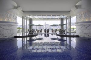 a lobby with tables and umbrellas in a building at The Peninsula Hong Kong in Hong Kong +15 photos