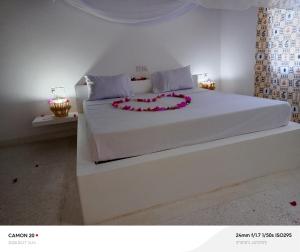 a bedroom with a white bed with a flower arrangement on it at Tranquil villa in Watamu