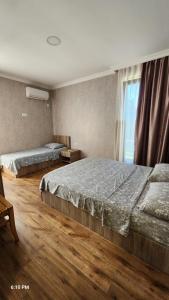 a bedroom with two beds and a window at Rio cottage apartment in Ureki