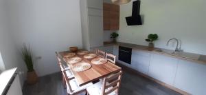 a kitchen with a wooden table with chairs and a sink at Ferienhaus Löwe in Niedenstein