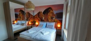 a bedroom with two beds and a large mirror at Ferienhaus Löwe in Niedenstein