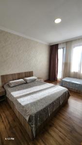 a bedroom with a large bed and two windows at Rio cottage apartment in Ureki +4 photos