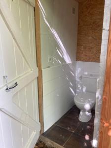 a bathroom with a white toilet and a door at Citerne-Lit in Montredon +5 photos