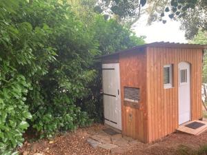 a small wooden shed with a door and a garage at Citerne-Lit in Montredon