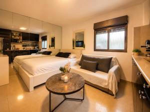 a bedroom with a bed and a couch and a table at Spa Mari TLV in Tel Aviv +19 photos