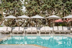 a swimming pool with lounge chairs and umbrellas at Summer Dream in Rethymno