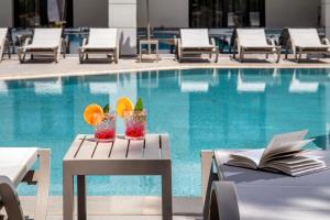 a pool with a table with drinks and a book at Summer Dream in Rethymno +9 photos