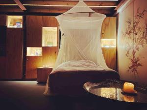 a bedroom with a bed with a net on it at Stijlvol Atelier in het groen in Liempde