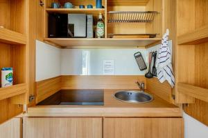 a kitchen with a sink and wooden cabinets at Chalet Campiglio Mountain View - Guardabassi Collection in Madonna di Campiglio +16 photos