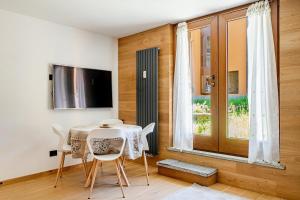 a dining room with a table and chairs and a window at Chalet Campiglio Mountain View - Guardabassi Collection in Madonna di Campiglio
