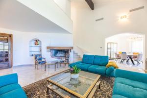 a living room with blue couches and a fireplace at Villa Excelsior in Porto Ota