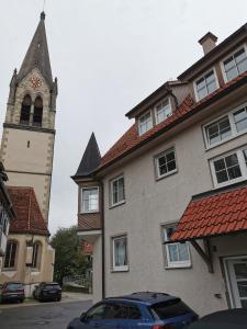 a building with a clock tower and a building with a car at Ferienwohnung Münsingen zentrum in Münsingen
