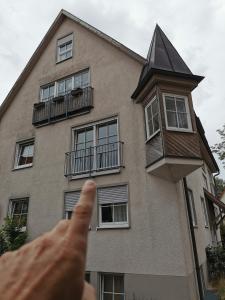 a person pointing at a building with their thumb up at Ferienwohnung Münsingen zentrum in Münsingen