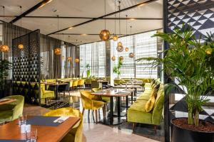 a restaurant with tables and chairs and plants at Barceló Anfa Casablanca in Casablanca