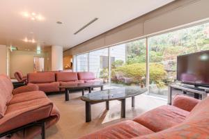 sala de estar con sofás y TV de pantalla plana. en Hakone Gora Onsen Yumenoyu, en Hakone