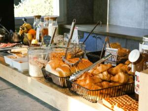 a counter with baskets of bread and other food at ibis budget Saint-Omer Centre in Saint-Omer +67 photos