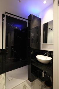 a black bathroom with a sink and a mirror at Relax in Puglia in Corato
