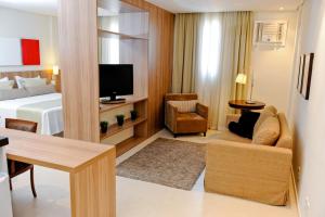 una camera d'albergo con letto e soggiorno di Faria Lima Flat Service a Sao Jose do Rio Preto