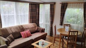 a living room with a couch and a table at Mobilhome 713 panoramique Siblu in Gastes