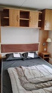 a bedroom with a bed with a cat laying on it at Mobilhome 713 panoramique Siblu in Gastes +35 photos