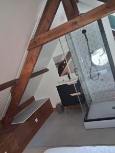 an attic room with wooden beams and a staircase at Chez Cosette, studio in Montreuil-sur-Mer