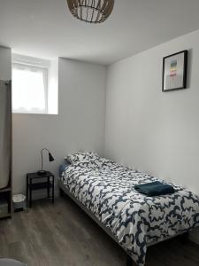 a bedroom with a bed with a black and white comforter at Gîte de l'hôtel Castel in Couvains