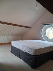 a bedroom with a bed with a round window at Chez Cosette, studio in Montreuil-sur-Mer