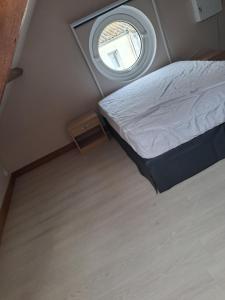 a small bedroom with a bed and a window at Chez Cosette, studio in Montreuil-sur-Mer +2 photos