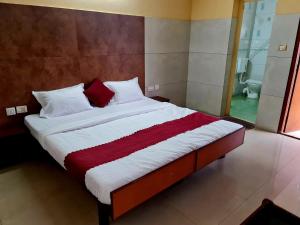 a bedroom with a large bed with red and white pillows at Hotel Royal Park in Mangalore