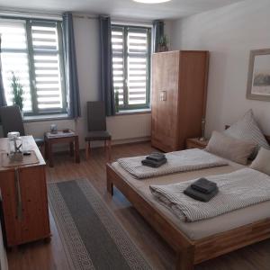 a bedroom with two beds in a room with windows at Pension am Bernsteinmuseum - Doppelzimmer in Ribnitz-Damgarten