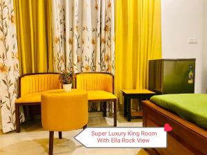 a room with a bed and two chairs and a tv at Rock Face Palace in Ella
