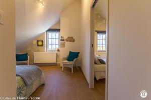 a bedroom with a bed and a chair in a room at Maison du Cosmos in Thorigny-sur-Oreuse +19 photos