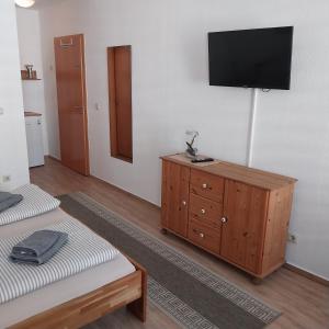 a living room with a television on a wall at Pension am Bernsteinmuseum - Doppelzimmer in Ribnitz-Damgarten
