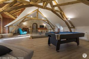 a room with a pool table in the middle of a living room at Maison du Cosmos in Thorigny-sur-Oreuse