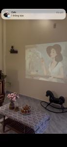 a room with a table and a picture of a woman at The Mê Linh House in Nha Trang