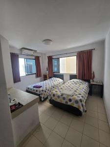 a hotel room with two beds and two windows at The Royal Pattaya Cantina Near Walking Steer in Pattaya South