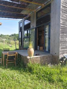 a porch of a house with a vase on it at La tiny house Low Tech in Cléder
