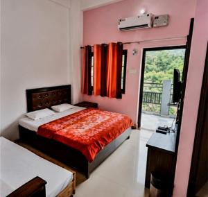 a bedroom with a bed and a television and a window at cp residency in Karnaprayāg