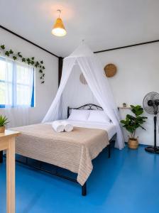 a bedroom with a bed with a mosquito net at Secret Place Hotel and Restaurant in Haad Yao