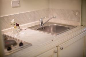 a kitchen sink with a vase with a flower in it at Santa Giulia Hotel e Residence Torino in Turin +60 photos