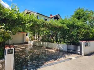a house with a fence and trees and a driveway at Ferienwohnung Prestele in Risika