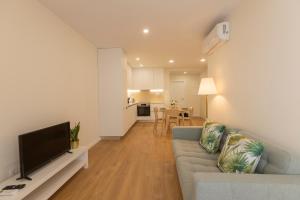 a living room with a couch and a flat screen tv at Coração dos Arcos in Arcos de Valdevez